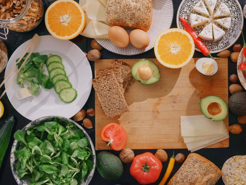 prikaz povrća, jaja i voća na stolu i drvenoj dasci